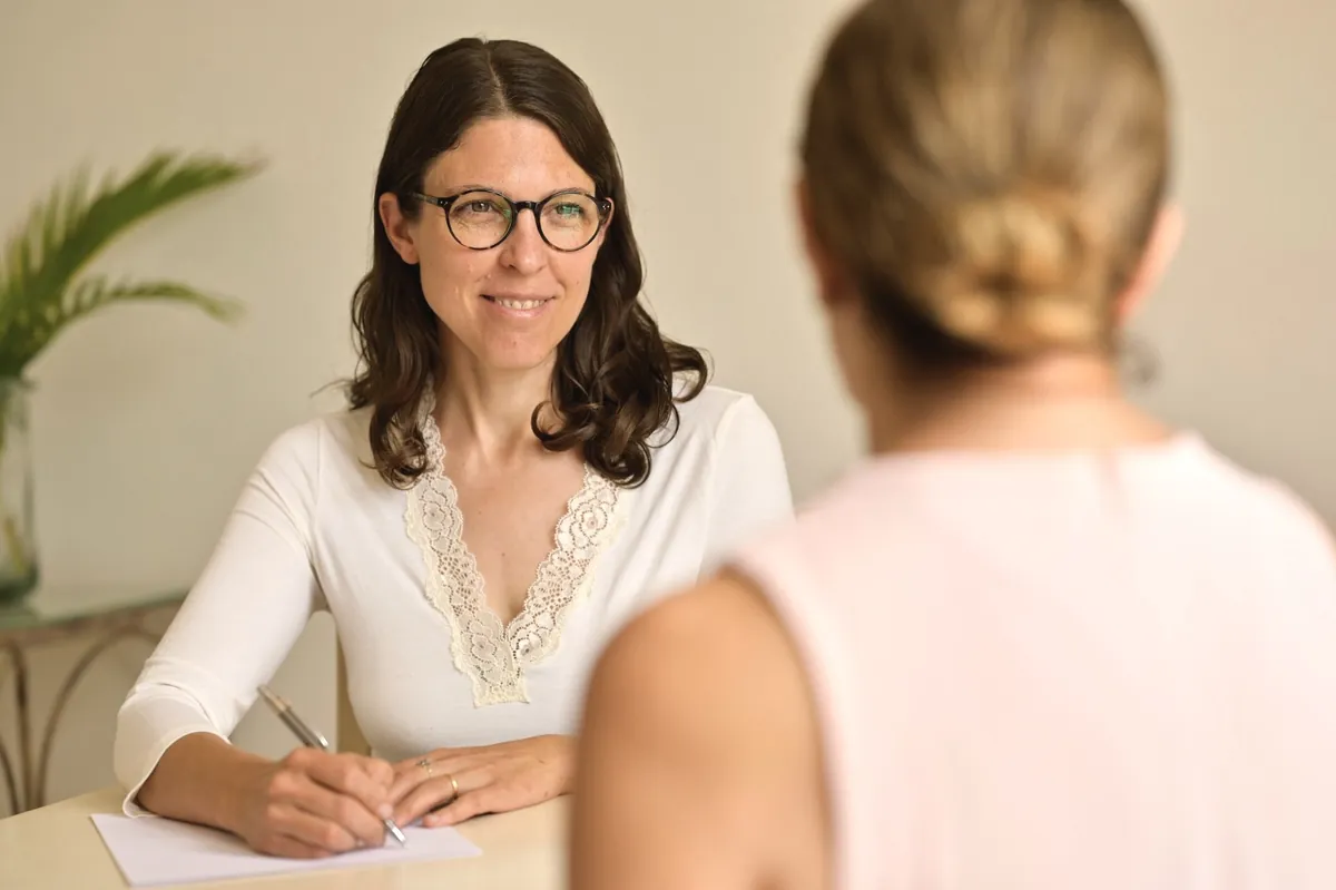 Melanie Schlachter en consulta terapéutica, escuchando y tomando notas como parte del diagnóstico integral.